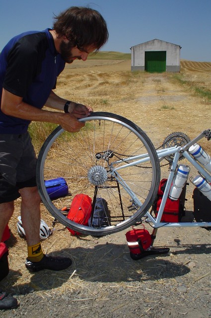 Changing my first flat tire on the way from Cordoba toward the mid-country Sierras.  This was a tough day of cycling (it was about forty km of elevation change, including marked 10% grades through a national park with no water) followed by a rough night sleeping in a drainage ditch in sheep and cattle ranching country (there were no hotels or campgrounds).  My sleep was interrupted by what I imagined to be predators in the grass (which in the morning turned out to be bunny rabbits).  (7/10/04)