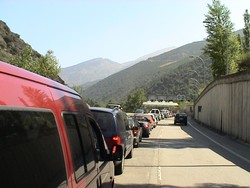 Waiting in line at the border to cross from Spain into the principality of Andorra, where people seem to go to shop duty-free amidst the scenic Pyrenees.  The Andorrans did not care one whit who came into their country, but the Spanish were creating a bit of a jam on the other side checking trunks to see if anyone bought one too many bottles or cartons of tax-free vice.  I zoomed by the drivers on my bike and entered Andorra and its lifestyles-of- the-rich-and-famous Ferrari boutiques without delay.  While I passed on the duty-free luxuries, I did go hog wild at the supermarkets so that I could later prepare camp meals fit for royalty.  The night before I hit the border an old Spaniard threw rocks at me in the campsite when I was setting up in the darkness.  When I started walking toward him to find out what the story was he said he thought I was a "Gato."  I understood the mistaken identity.  (7/27/04)