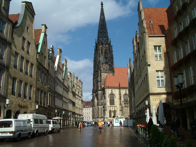 I am really glad that I decided to pay M�nster a visit.  It has a really strong college town feel (which I always love), with over 50,000 students, and there are tons of cyclists, book stores, and health food stores (where I can buy a liverwurst-like spread made out of smoked tofu - it tastes great on my morning br�tchen).  It has been raining here off and on, and there were about twelve or so rain showers here today that I noticed.  This is a picture of St. Lamberti church with the sun sparkling on rain-soaked cobblestones in the center of the Altstadt.  If you click on the photo twice you can see three metal cages above the church�s gold clock dial.  In the sixteenth century some Anabaptists declared M�nster the headquarters of their new religious paradise.  The catholic authorities decided not to join and instead promptly tortured and threw the three main instigators into these metal cages to die high above the town.  There are a couple of other interesting cathedrals in town, one of which houses a giant statue of St. Christopher, the patron saint of travelers - the statute is actually holding an authentic giant tree trunk in his hand as a walking staff.(9/21/04)