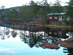 After Oslo it was another five day journey eastward to the next Scandanavian capital, Stockholm.  This took me through Swedish lake land, past one mirror flat lake after another.  And that is not an exaggeration - I have never seen bodies of water that large lie so still.  This is one of many lakes that I passed (again with the red Swedish house), this time in the evening as I was scouting out a camping site.