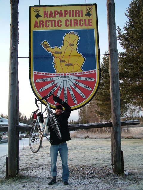 In the morning after arriving in Rovaniemi, on November 14, 2004, after nearly nearly five months of cycling, I cycled the remaining 8 kilometers north to the Arctic Circle marker, and raised the trusty cycle in celebration.  It felt really great to have made it.  In case you did not know, the arctic circle marks that point on the earth's surface where during the summer there is at least one day where the sun never sets, and where during the winter there is at least one day where the sun never rises (at least that was what the informational sign told me).  Nearby was the Santa Village (which is sort of like Finland's Frankenmuth) where it is Christmas 365 days a year.  (11-14-04) 