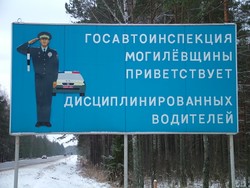 The road signs are all in cyrillic, so the 8 units of Russian that I took in college have finally paid off, although all I remember is how to read the alphabet and only the most basic phrases, so I have no idea what this sign says.  Someone needing a creative artistic release must have decorated the Belarus highway signs, because the signs involved a lot more illustration than is the case elsewhere.   The illustration of the police officer and his car here is a pretty reserved example, although the detailing is pretty excessive.  Elsewhere no-passing signs were illustrated with two corvettes competing on the road with a wave of coffins floating off into the sky in front of them, to provide another example.  (12-20-04)