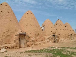 I made a day trip by bike from Hama out to the crumbling remains of the crusader castle, Qasr Ibn Warden, and along the way stopped at a village full of these baked mud beehive houses.  Some of them are still in use, but most of them are used for storage.  (3/22/05)