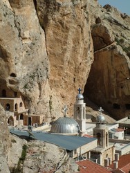 Later that day I cooled my heels at Maloula, a small Aramaic speaking Christian village carved like a little piece of blue and white cross-topped Greece into the mountain cliffs.  After giving one of the sisters a donation in an amount that I calculated to be the equivalent of a cheap hotel room (hey, I'm no freeloader - most of the time) I spent the night sleeping at the Convent of St. Tekla surrounded by black robed nuns wearing black woolen hats that were shaped like crusader helmets.  My favorite part was the evening prayer call in Aramaic.  Similar to the mosques, the convent broadcast an evening call that echoed against the cliffs, but it was sung in a call and answer form by two nuns with beautiful voices.  There was a narrow canyon passage behind the convent that can only be compared to the siq at Petra, except that it was covered in defacing graffiti.  The next morning I awoke to the sounds of busloads of Syrian christian pilgrims who were giving the convent gift shop a good deal of trade in icon reproduction purchases.  (4/7/05)