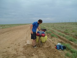 The bitter agony of defeat . . .  Anyway, the continuity of the overland bike trip was regrettably interrupted here (but resumed again in Nukus).  I felt there was no way to go on with conditions that required pushing the bike where I had no means of buying food and water that would run out.  So I had to pack it in, and turn tail for Beyneu.  I had reached within 20 kilometers of the Uzbek border at the time of this photograph recording the moment of defeat.  Actually, it felt like a moment of divine intervention, because I can tell you that travelling through territory like this is not the most rewarding of travel experiences.  The morning after next (I missed the next day's train) I bought my train ticket to Nukus, and rumbled along to the Karakalpakstan capital where I started the bike ride again.  Right now I am in Urgench, and should have an Uzbekistan update within a week or so.  Kazakhstan . . . what a wierd leg in my now non-contiguous bike journey.  (6-07-05)